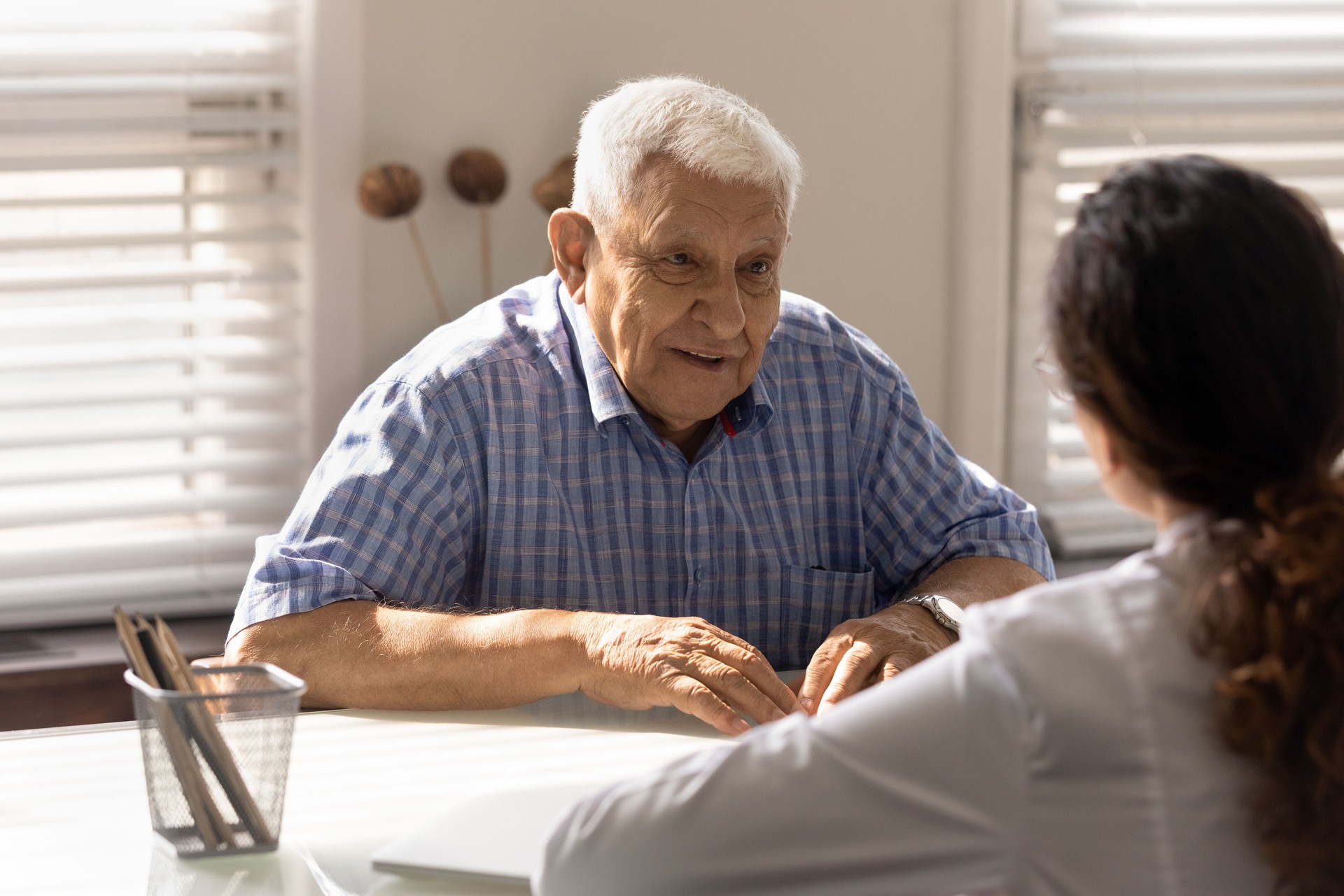 Positive senior 80s patient consulting doctor at appointment